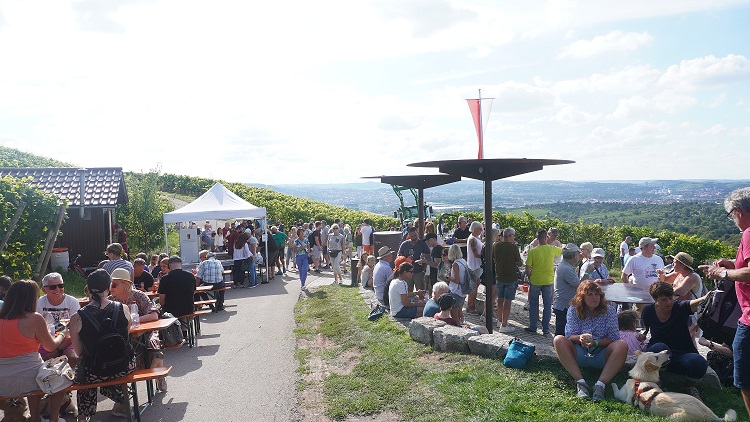 Viele Menschen treffen sich an einer Station am Fellbacher Kappelberg bei einer Weinwanderung